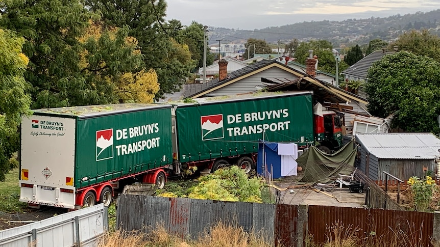 A B-double truck crashed into the back of a house, which is badly damaged.