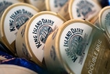 A dozen King Island Dairy double brie cheese wheels splayed with their labels showing.