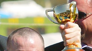 Jockey Glenn Boss celebrates with trophy after winning the 2003 Melbourne Cup.