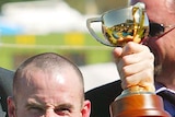Jockey Glenn Boss celebrates with trophy after winning the 2003 Melbourne Cup.