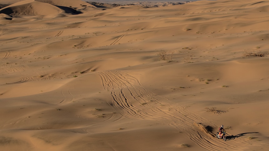 Toby Price rides his motorbike between sand dunes in the Saudi desert during the Dakar Rally first stage