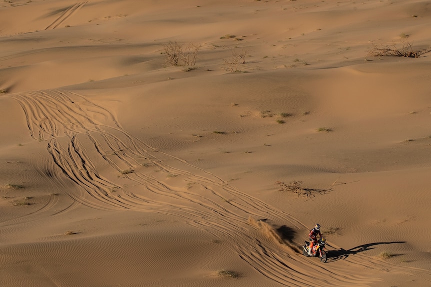 Toby Price rides his motorbike between sand dunes in the Saudi desert during the Dakar Rally first stage