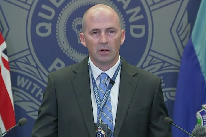 Queensland Police Service Detective Inspector Ben Fadian standing at lectern, addressing the media