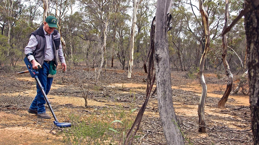 Ian Fenselau using a metal detector to search for gold