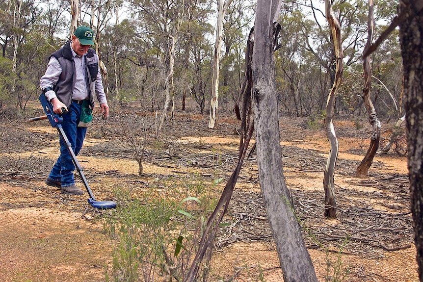 Ian Fenselau using a metal detector to search for gold