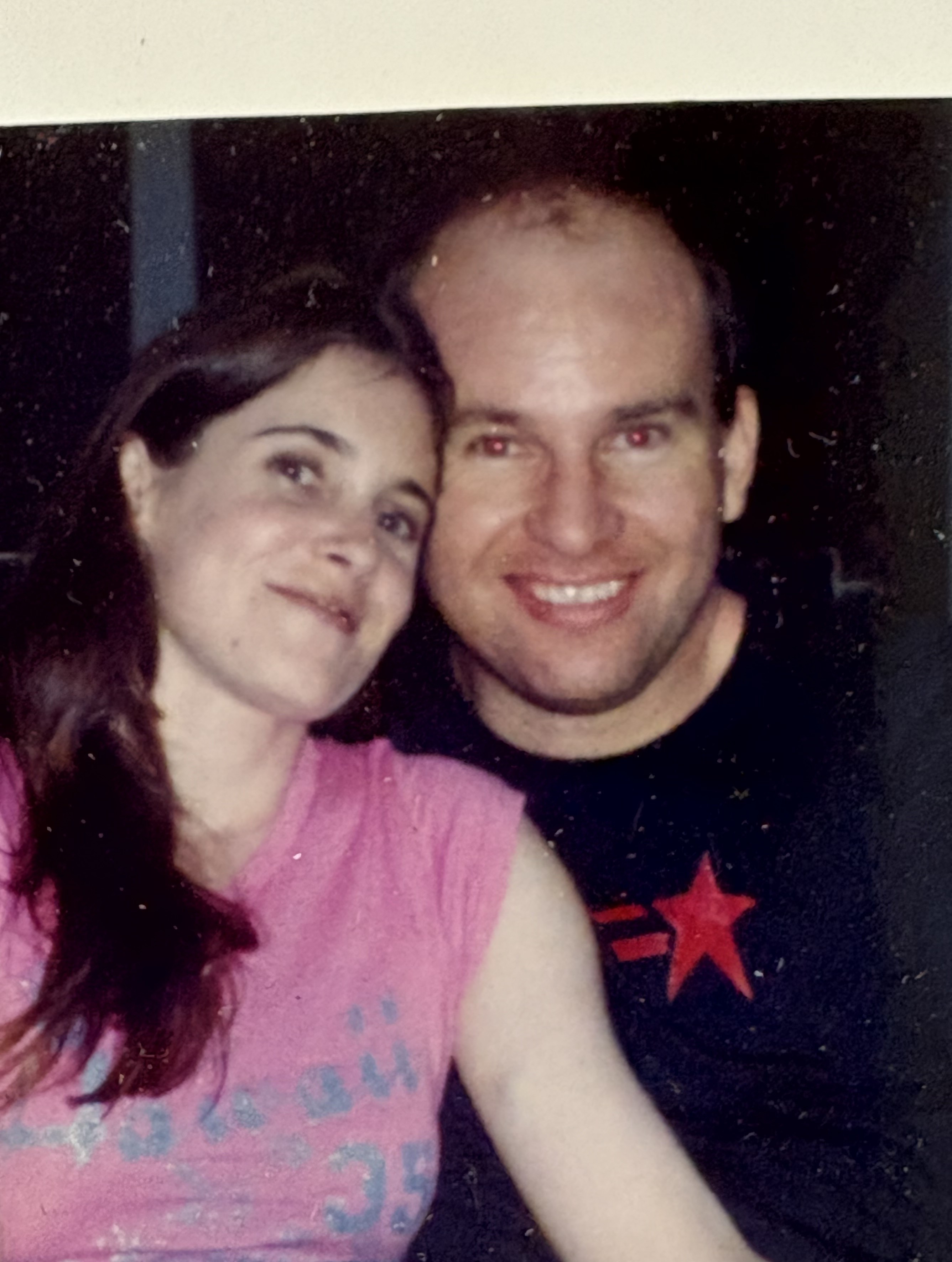 A woman in a pink shirt and a man smiling at the camera