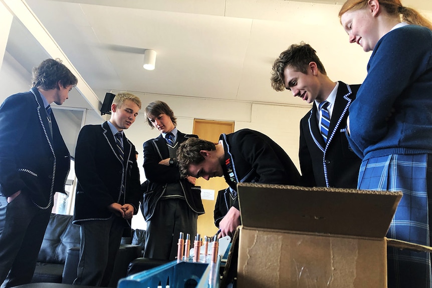 Students examine a piece of kit plane