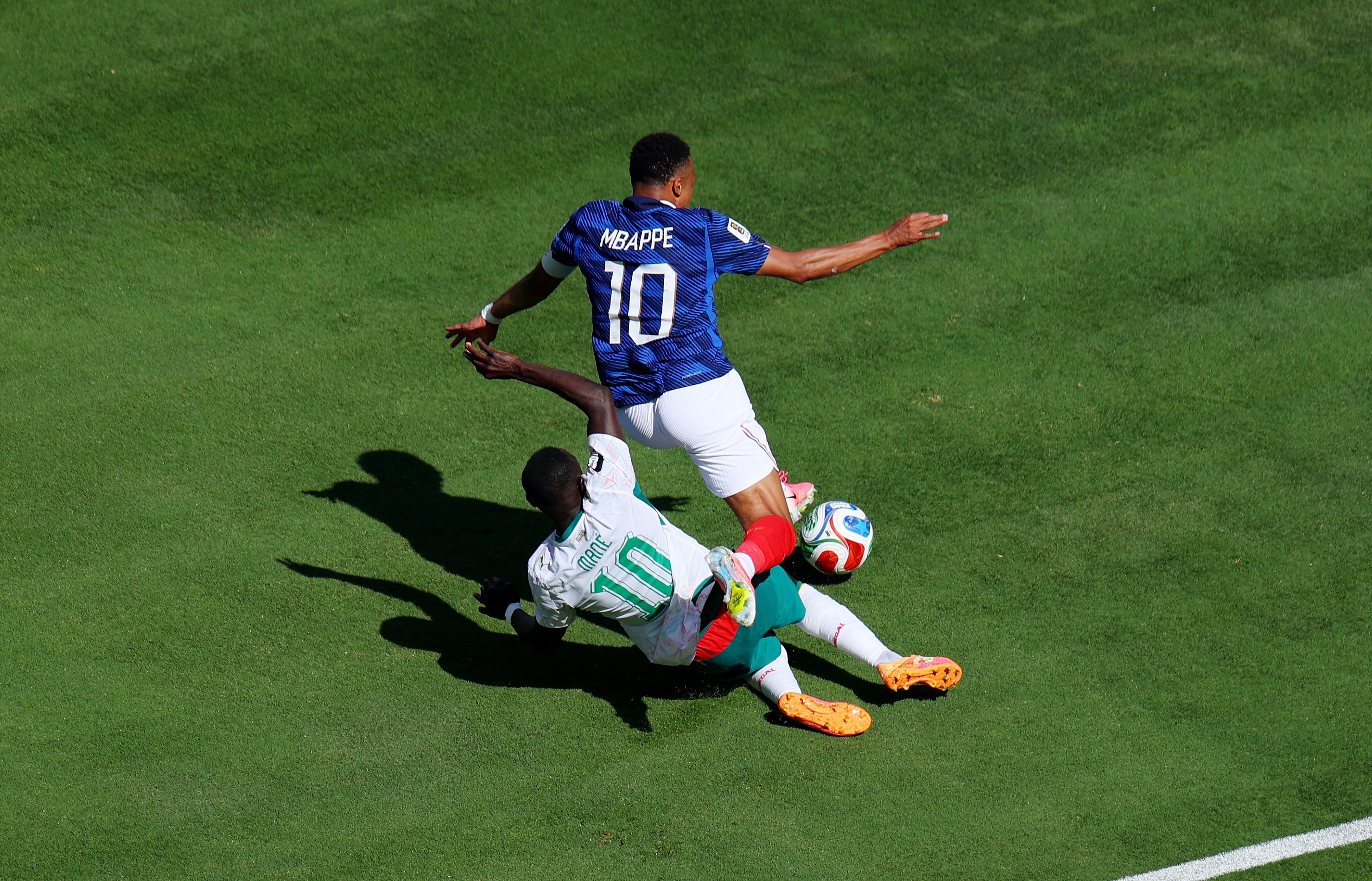 Sadio Mané hits the ground under Kylian Mbappé.
