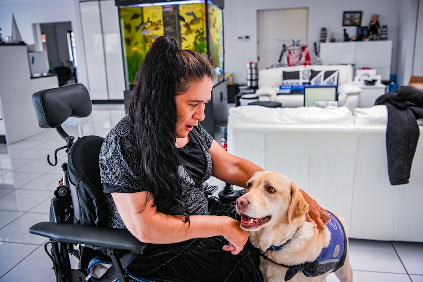 Tanya pats her assistance dog.