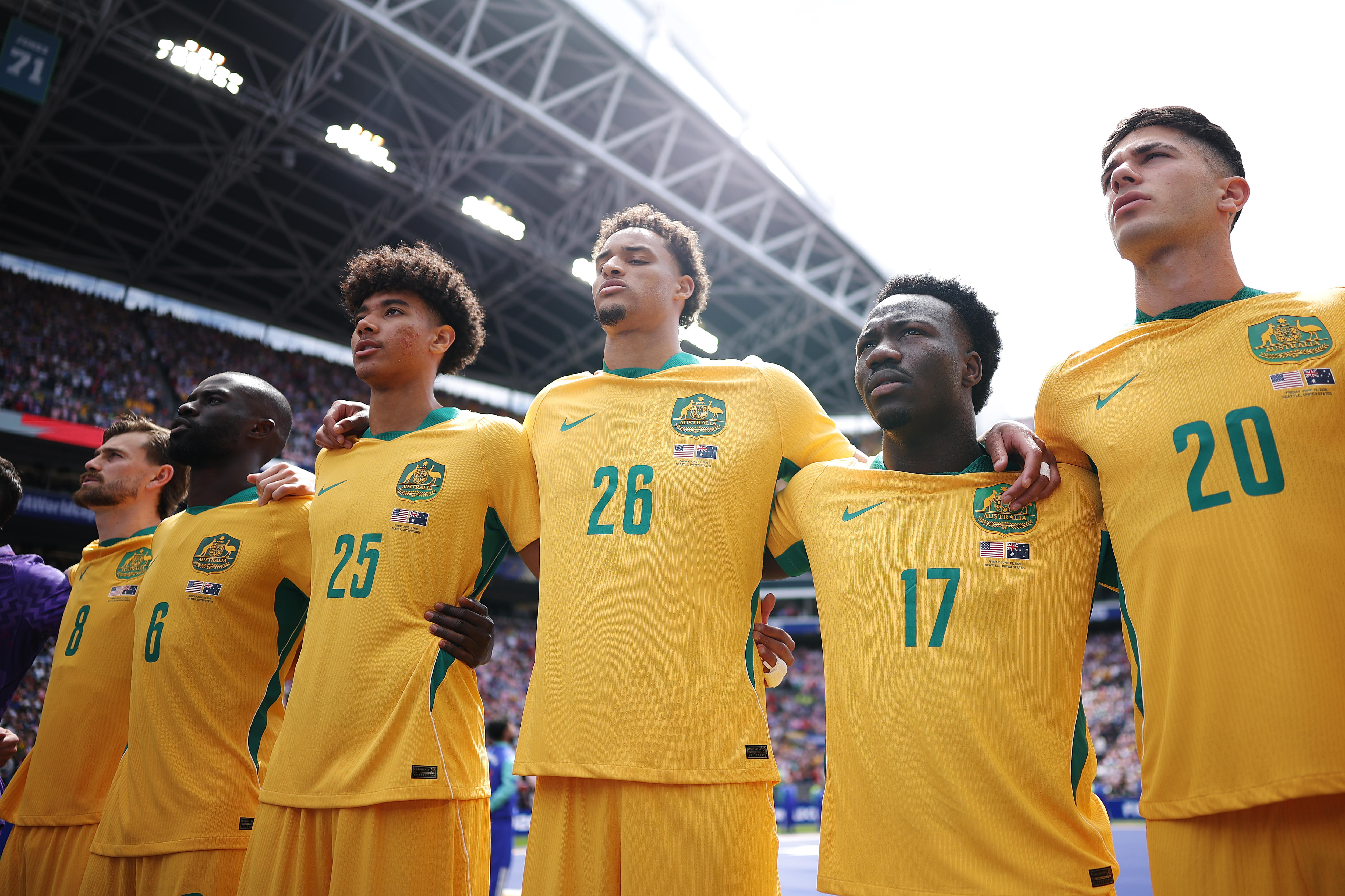 Socceroos players sing the national anthem