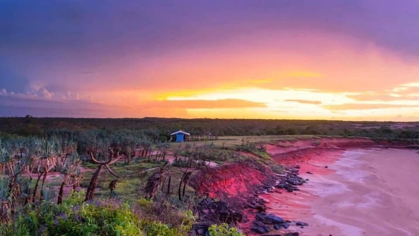 A drone photo of sunset on a remote, red coloured coast line