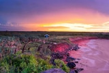 A drone photo of sunset on a remote, red coloured coast line