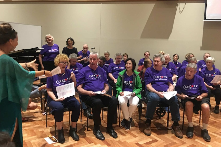 A choir practices singing during a rehearsal