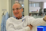A scientist in a lab coat smiling