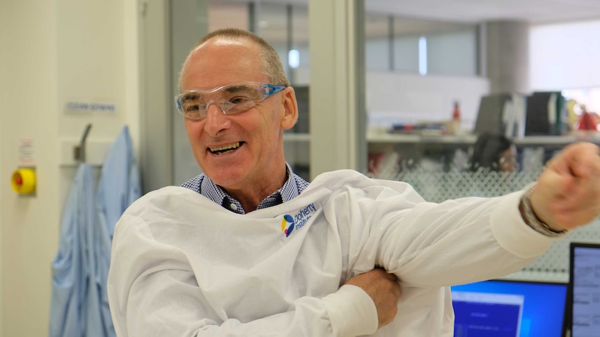 A scientist in a lab coat smiling