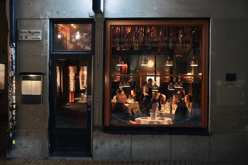 People sit at tables in a restaurant in Stockholm in late March.