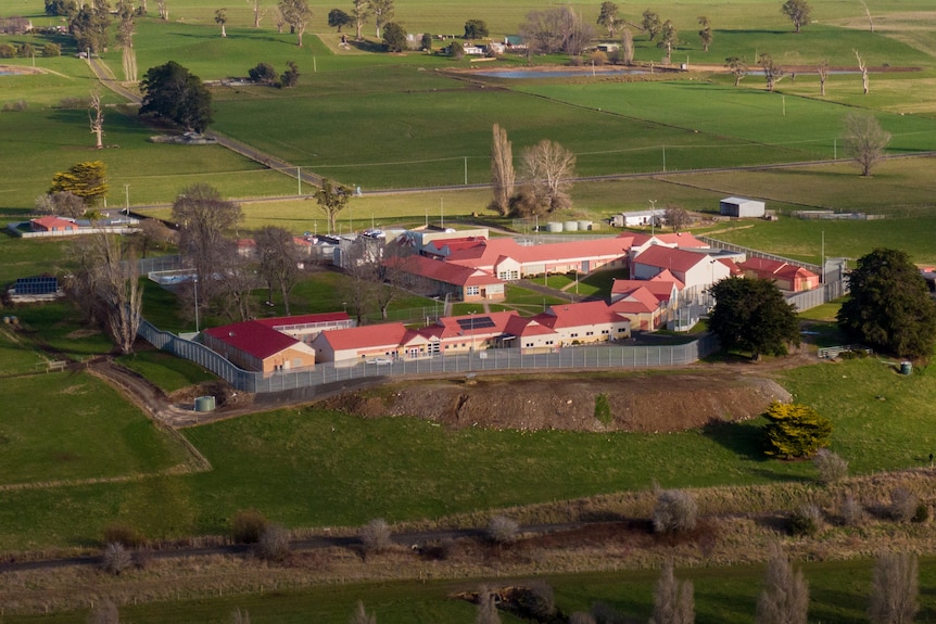An aerial view of Ashley Youth Detention Centre, pile of buildings surrounded by green grass.