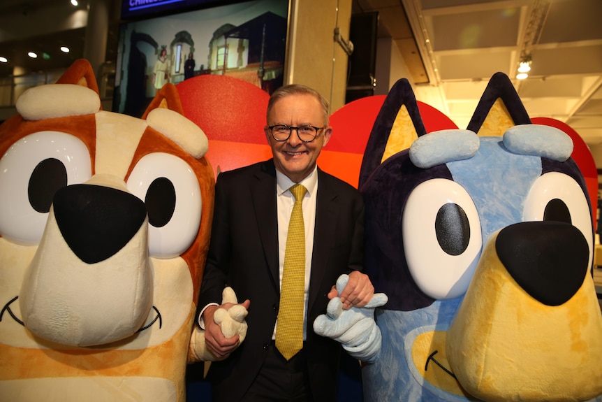Anthony Albanese holding hands with human-sized Bluey figures