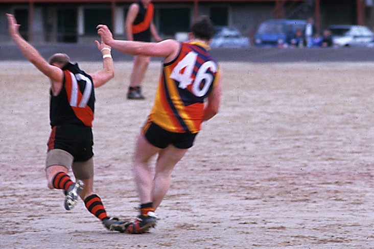 Footballers play on Queenstown's gravel oval in Tasmania's west.