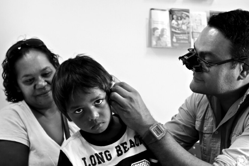 Doctor examines ear of Indigenous child