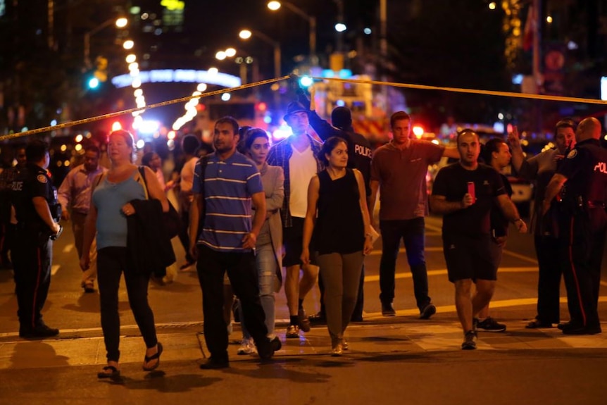 People leave an area taped off by the police.