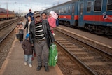 Refugees fleeing the war in Ukraine walk on a platform after disembarking from a train