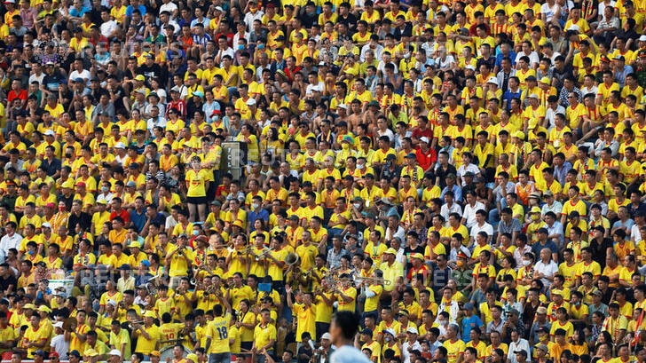 Thousands of fans pictured watching the soccer match, wearing yellow shirts and team colours.