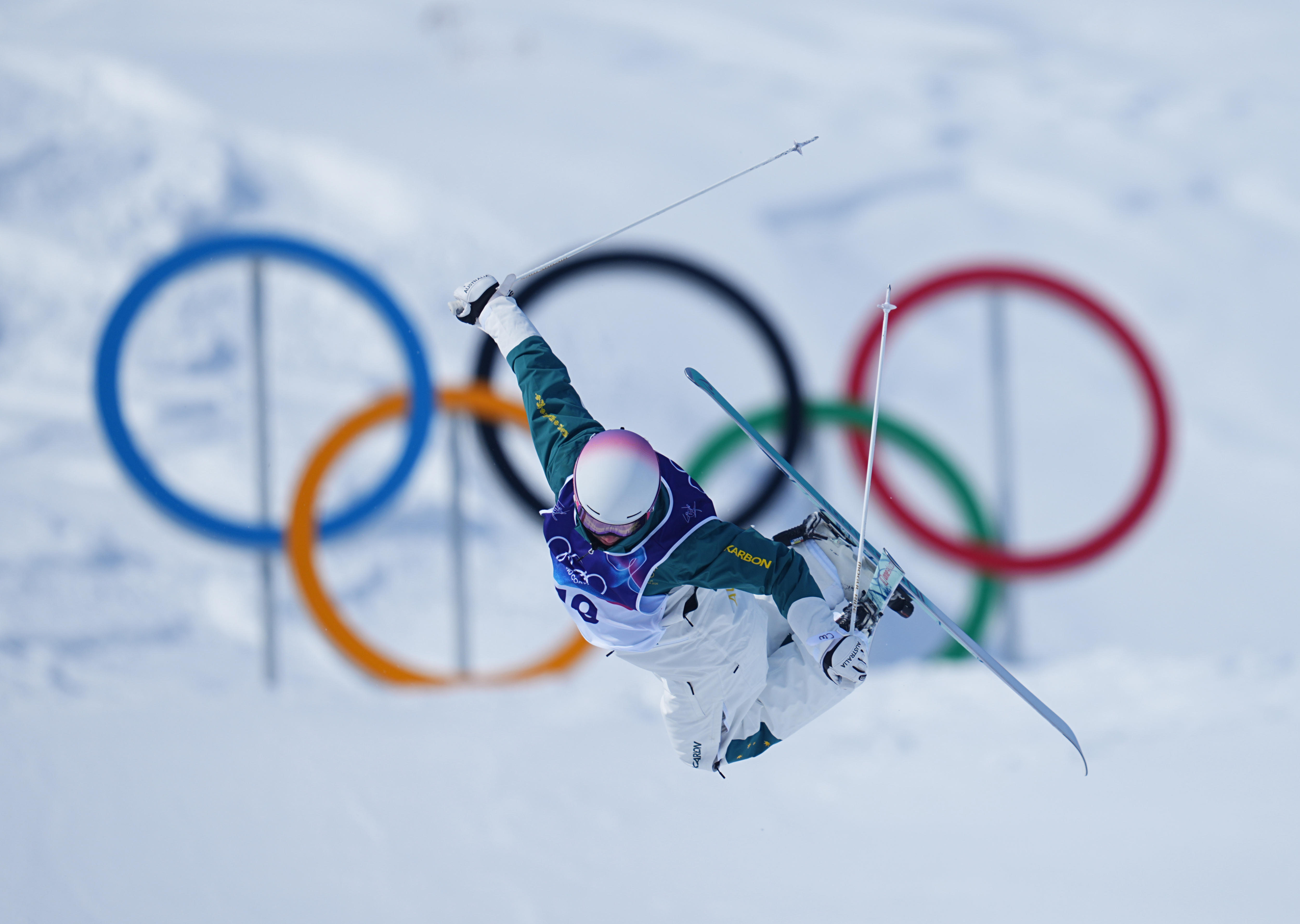 Cooper Woods salta na frente dos anéis olímpicos