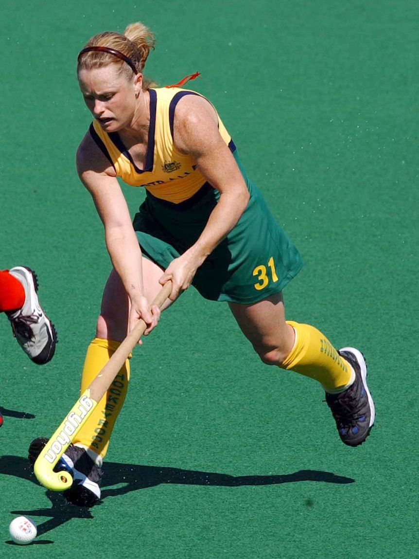 Katrina Powell with hockey stick in hand dribbles the ball