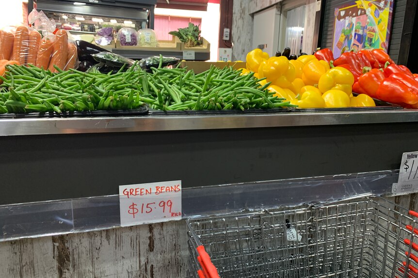 Green beans on the shelf with a price tag.