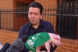 Politician Nick Xenophon holds a pig.
