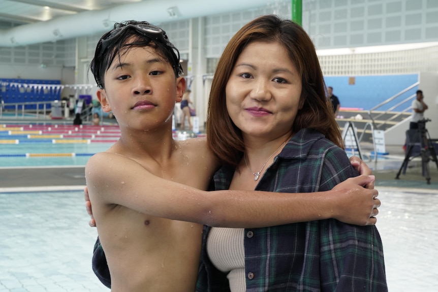 A young boy and his mother at a pool