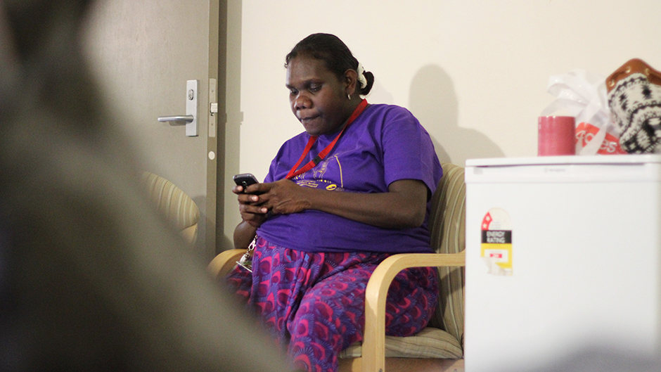 a woman sitting in a chair typing on a mobile phone
