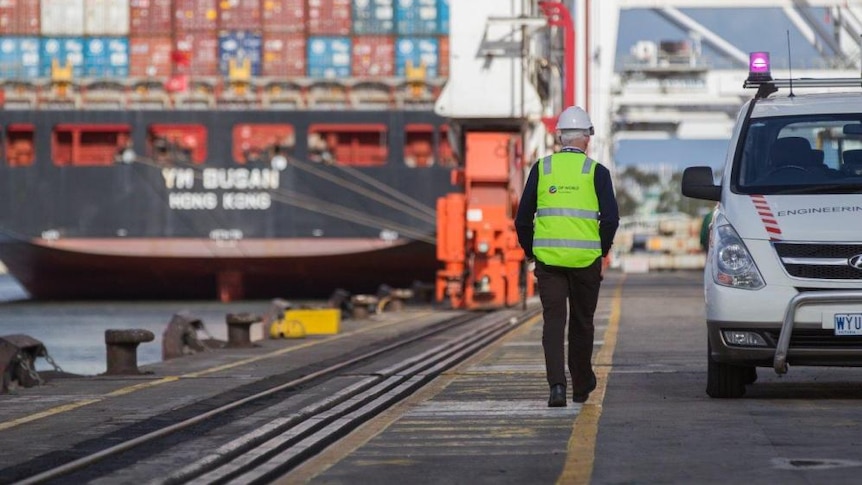 An employee of DP World walking along the Melbourne wharves