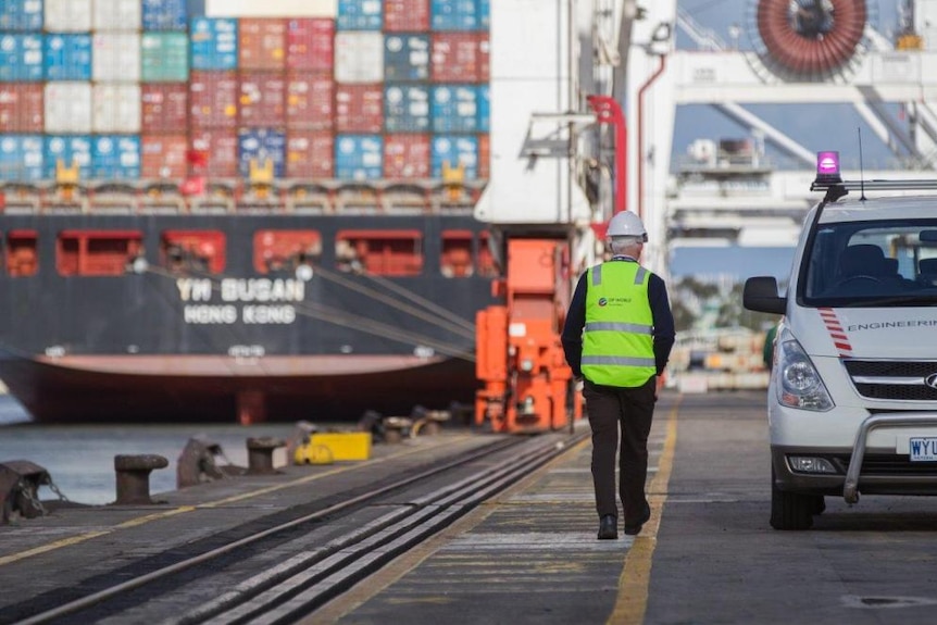 An employee of DP World walking along the Melbourne wharves