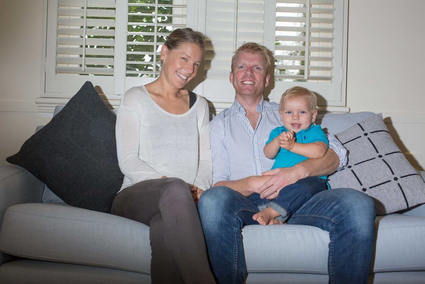 Eliza and Tim Vesey on the couch with their baby, Charlie