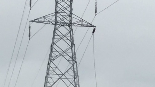 A large tower with a power line hanging off it