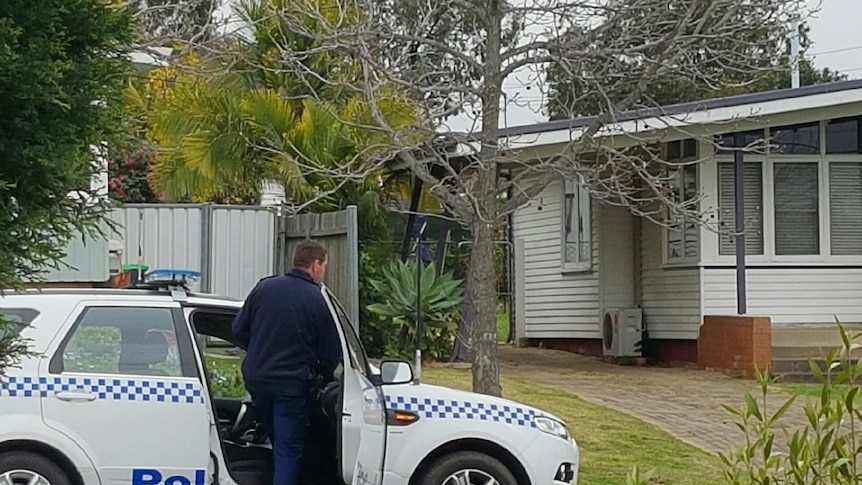 Police officer getting into a car in front of a property raided by counter-terrorism police.