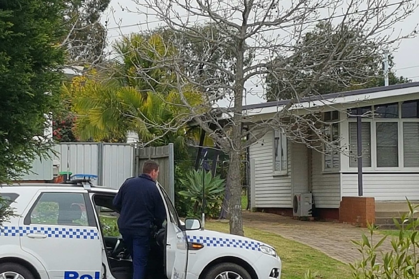 Police officer getting into a car in front of a property raided by counter-terrorism police.