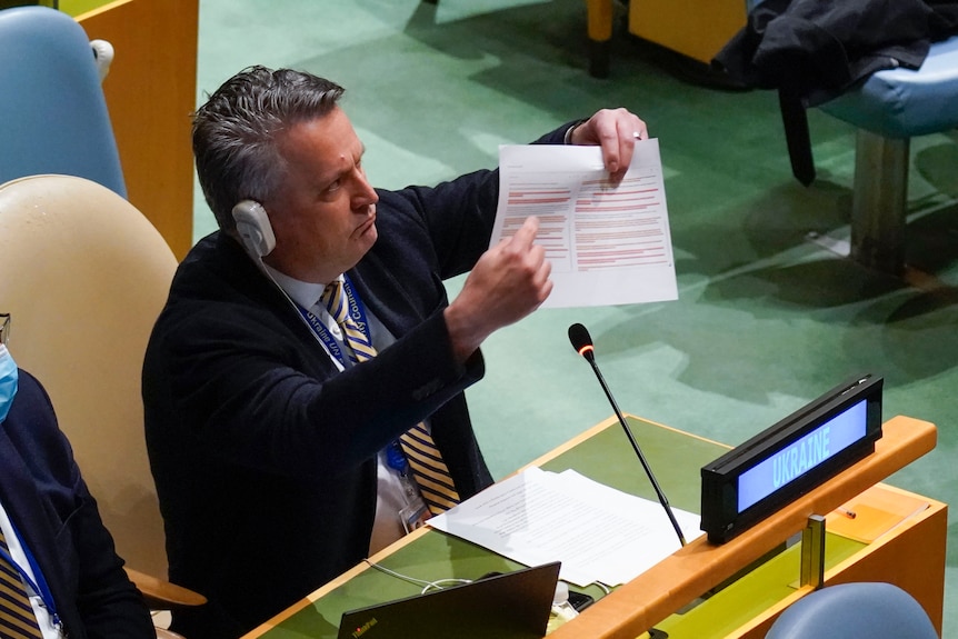 Ukranian Ambassador to the United Nations Sergiy Kyslytsya holds up a paper and points at it during a UN meeting.