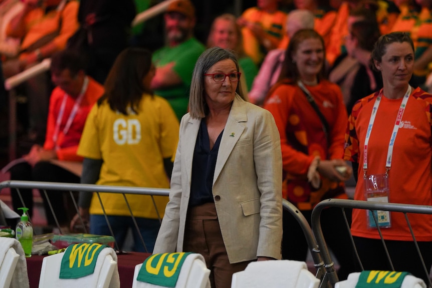 Leech stands behind a row of chairs with netball positional bibs on them