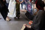 A homeless woman asks for money on a Sydney street