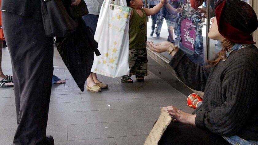 A homeless woman asks for money on a Sydney street.