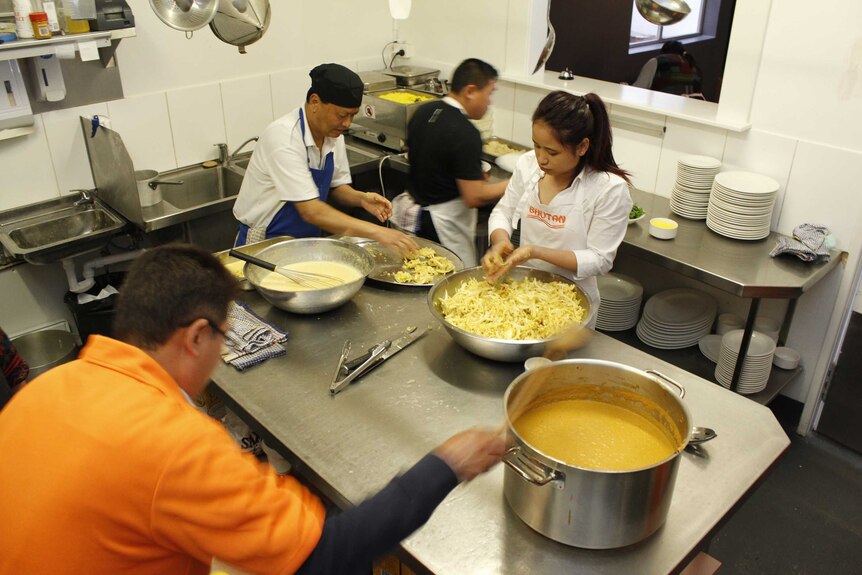 The kitchen at the Inveresk Tavern is busy with help from the local Bhutanese community