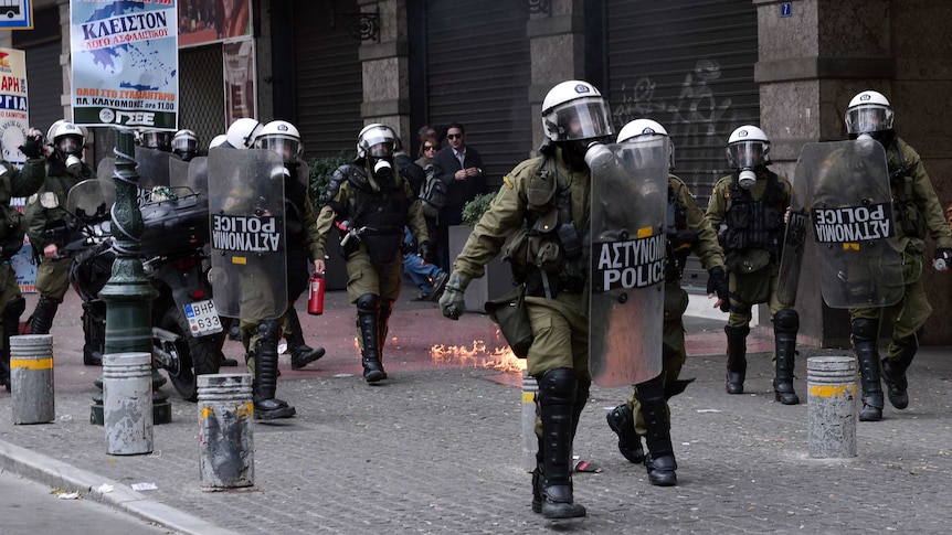 Riot police chase protesters in central Athens during a massive protest.