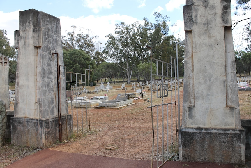 the gates of an old cemetery with headstones in the background