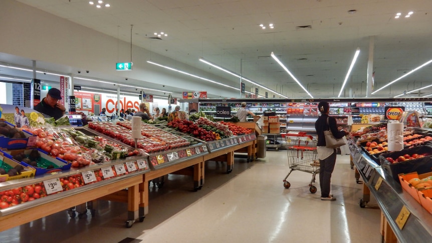 Shoppers in the fruit and vegetable aisle at Coles.