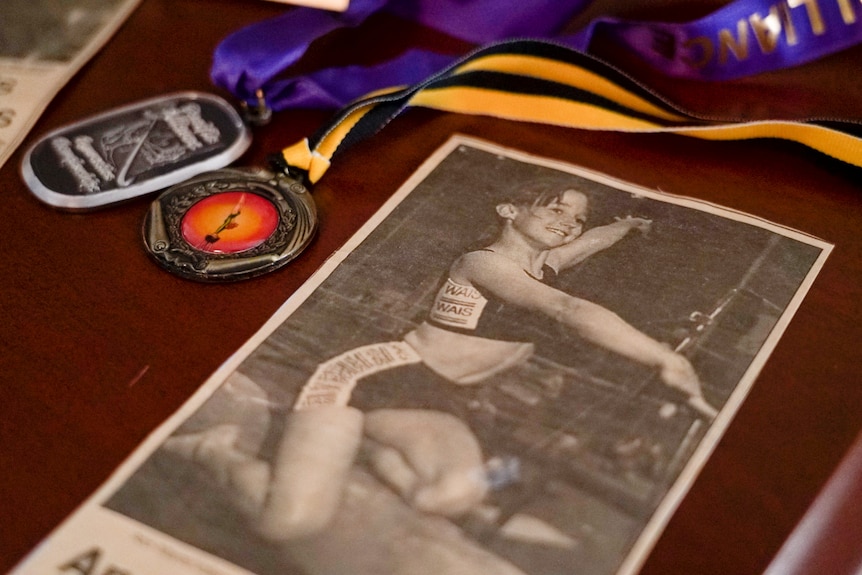 A newspaper clipping on a desk alongside several medals.