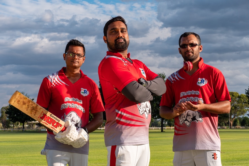 Three Indian medical workers dressed in cricket uniforms