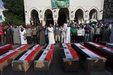 Supporters of Mohamed Morsi gather behind empty coffins during a fake funeral at Cairo's Rabaa al-Adawiya mosque.